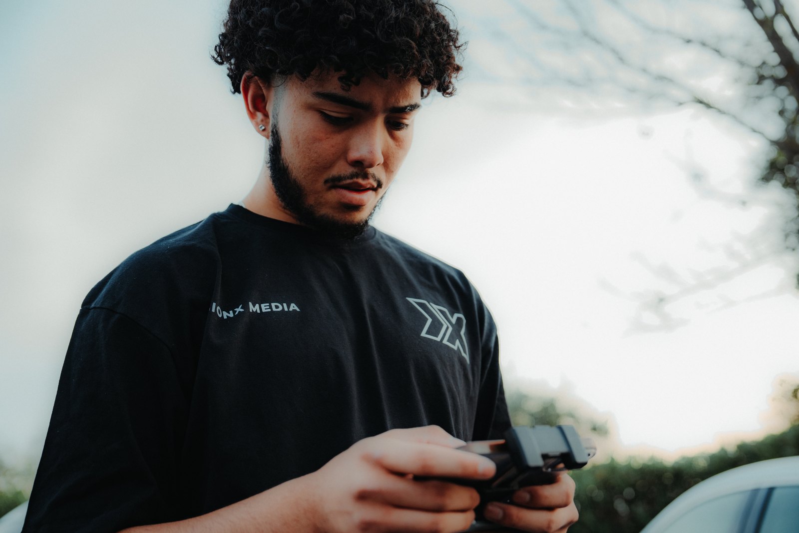 A Visionx crew member operating a drone controller outdoors