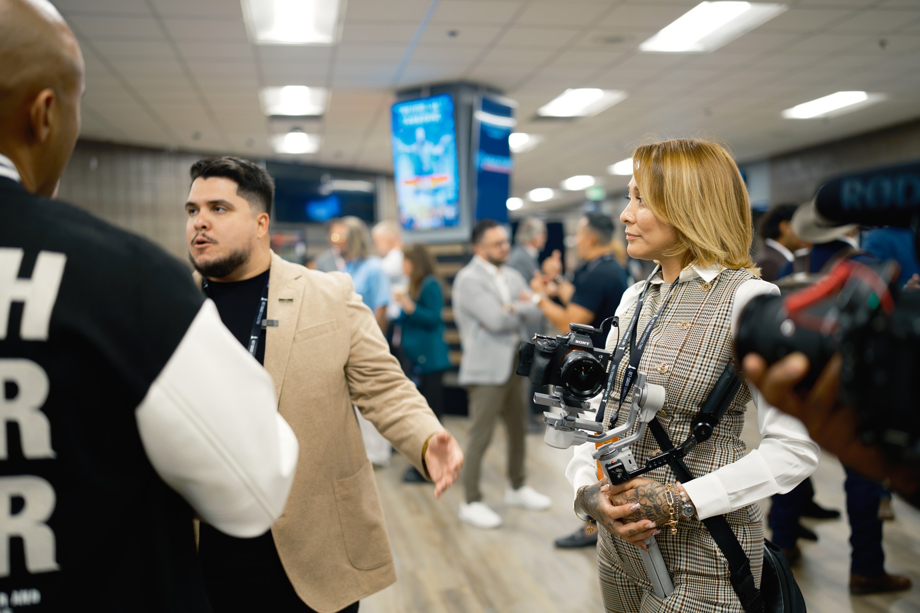 Crew members talking on the event floor with a gimbal camera ready